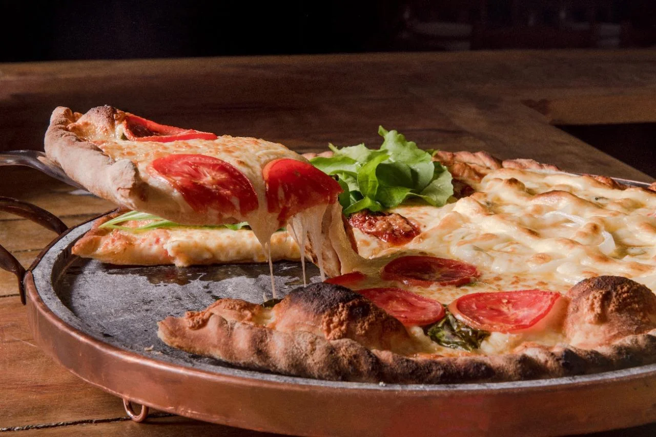 Pizza de Forno a Lenha com fatia saindo do forno